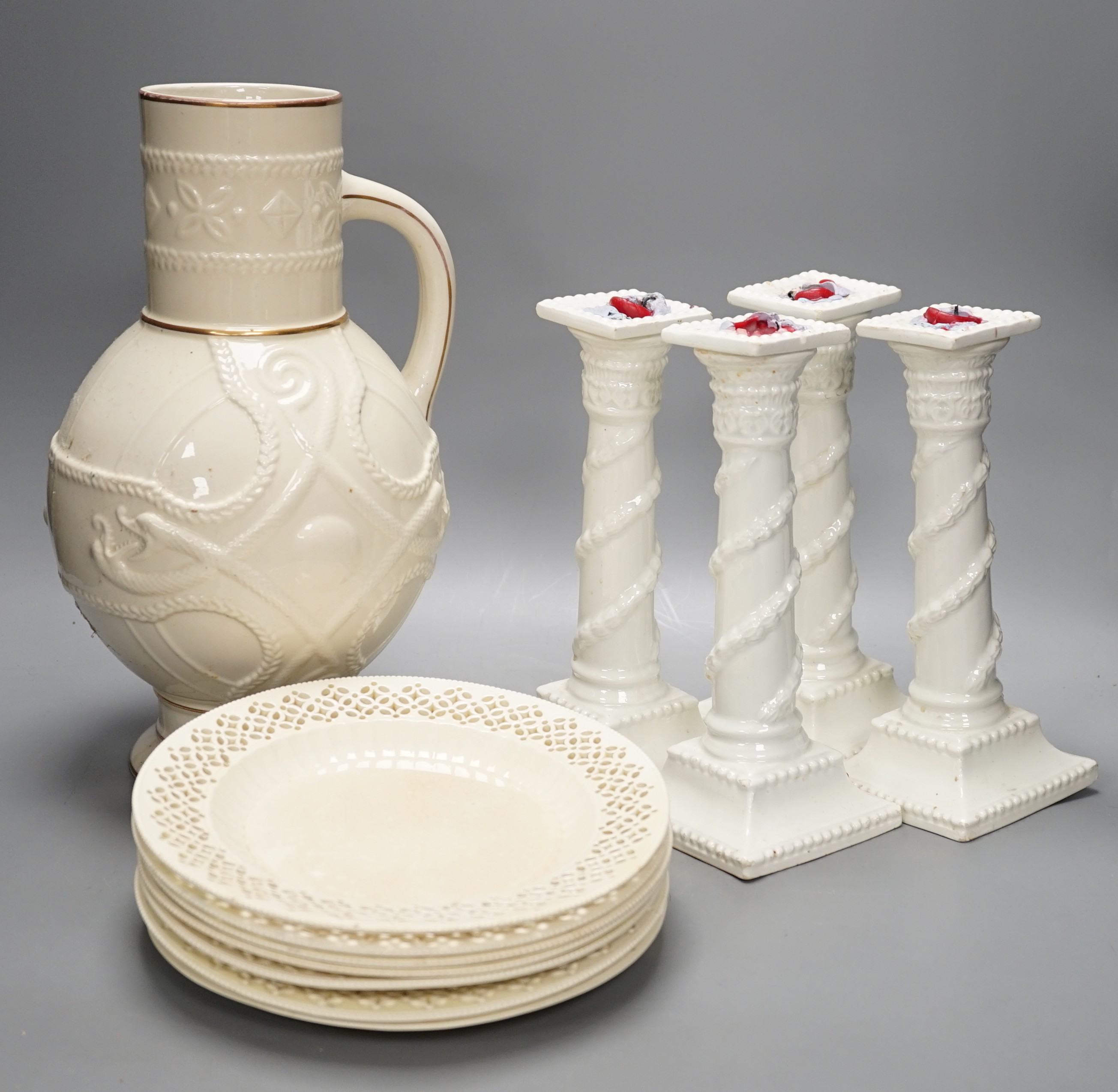 A set of seven early 19th century creamware plates, four later creamware candlesticks and an ivory ground jug. Tallest piece 33cm